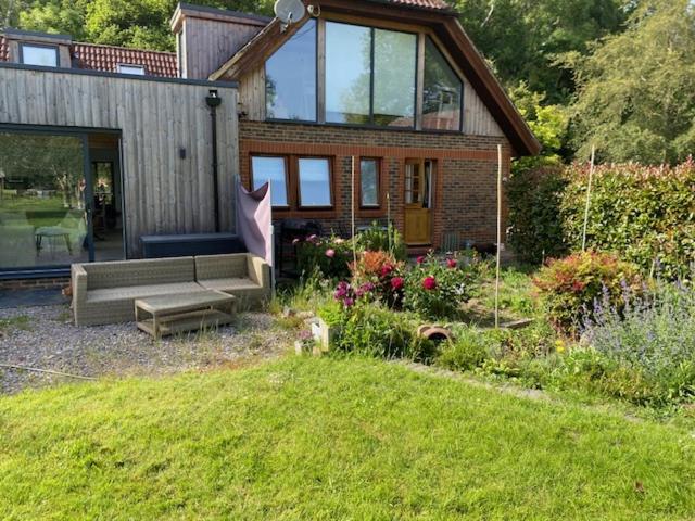 a house with a couch in the yard with a garden at Carpenters-stay in Dorking