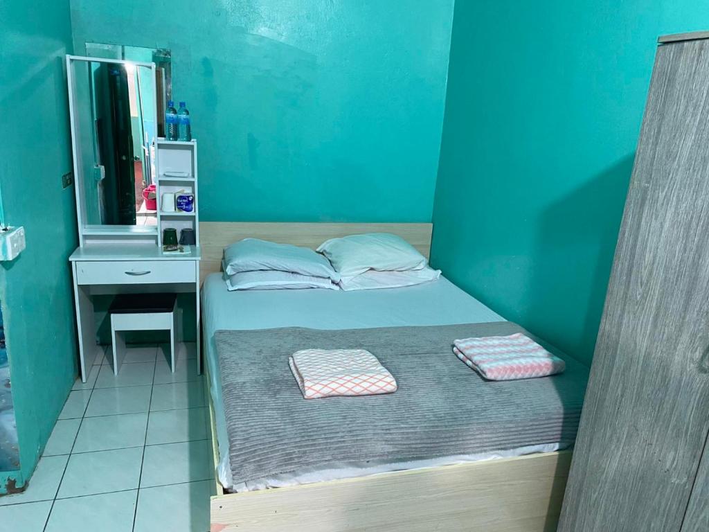 a small bedroom with a bed and a sink at Wind Stay in Male City