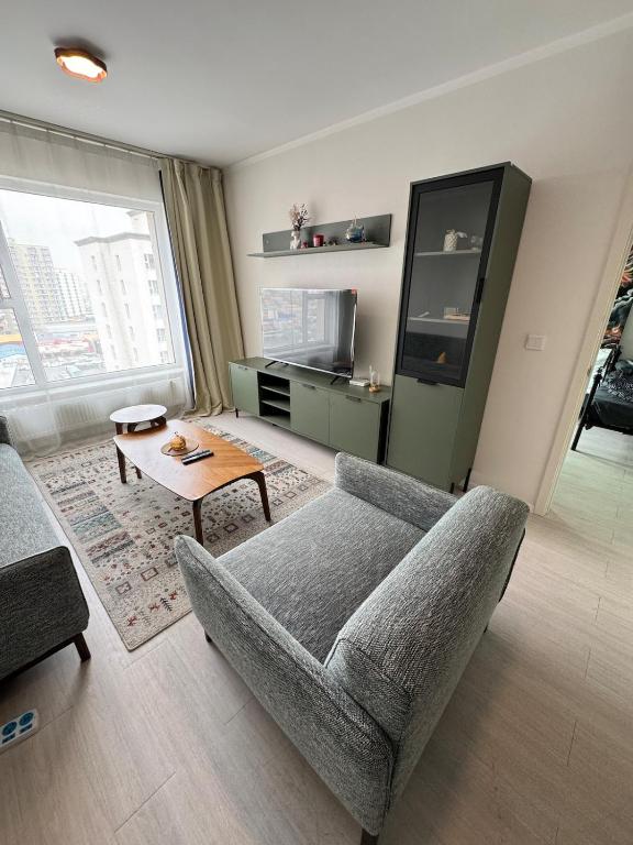 a living room with a couch and a table at Cozy Apartment newly furnished in Ulaanbaatar