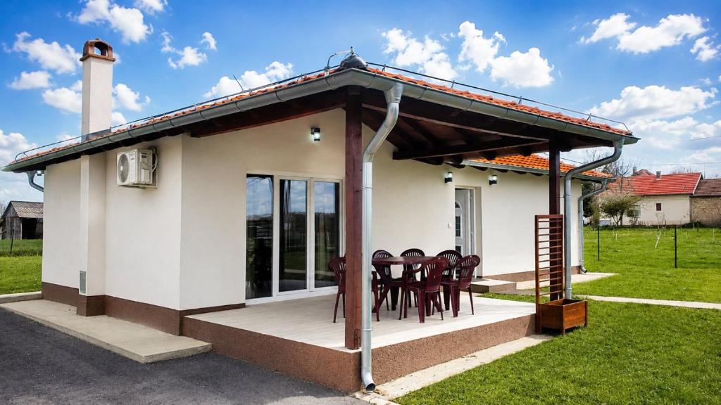 a small house with chairs on a porch at Šumadijski Pogled in Pružatovac