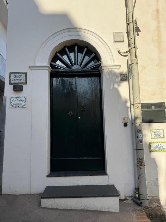 a black door on the side of a building at Casa Costanza in Capri