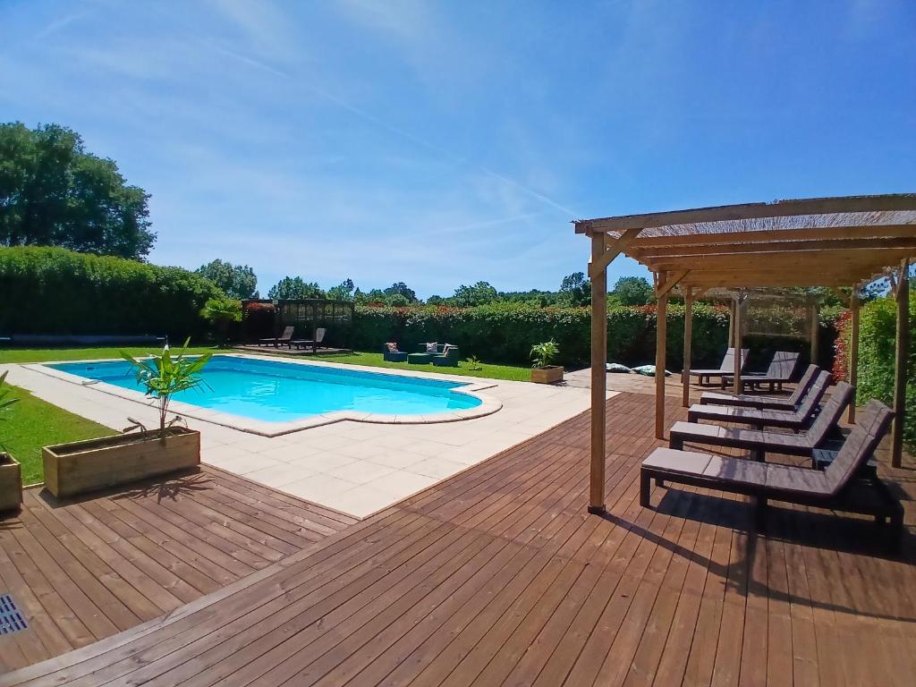 a deck with lounge chairs and a swimming pool at La Vieille Fromagerie in Brux