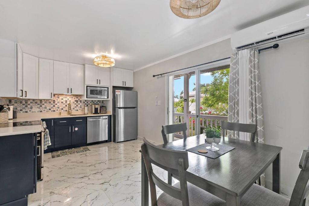 a kitchen with a dining table and a large window at Newly Renovated Condo in Christiansted