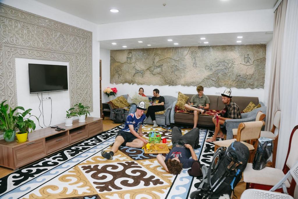 a group of people sitting in a living room at Apple Hostel Bishkek in Bishkek