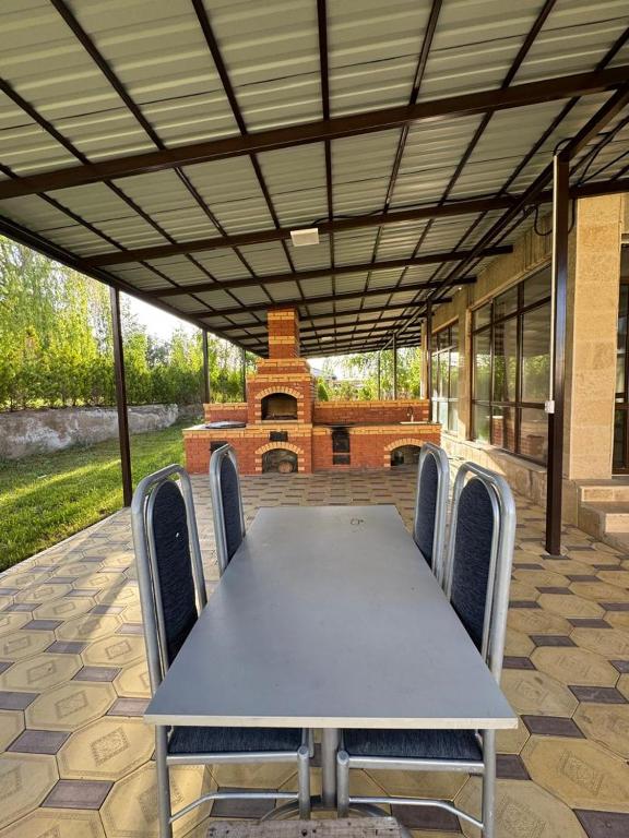 a table and chairs on a patio with a fireplace at Коттедж в Азиа Палас in Chon-Sary-Oy