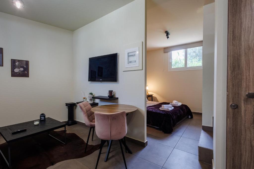 a room with a table and a bed and a desk at Olive and Sea Suites in Kalamata