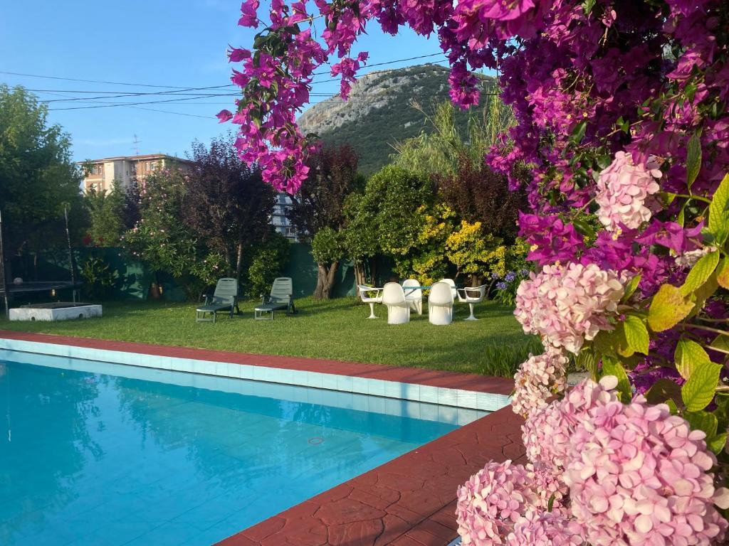 a garden with a swimming pool and flowers at La Choza in Oriñón