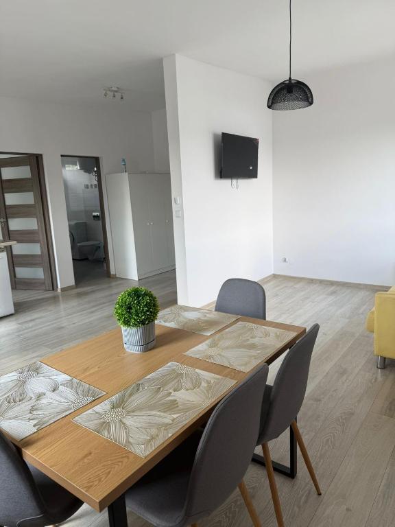 a wooden table and chairs in a living room at Wenecja Apartment in Wadowice