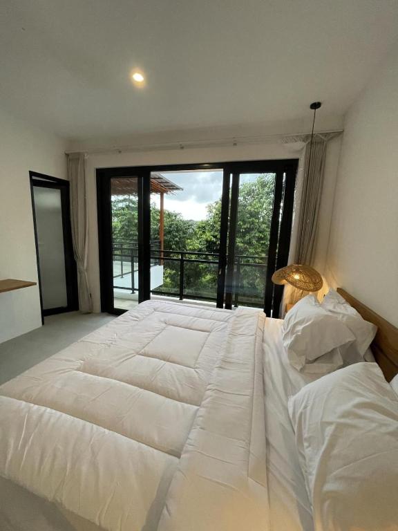 a large white bed in a room with a large window at Villa Rosa Dreams 2 in Ungasan