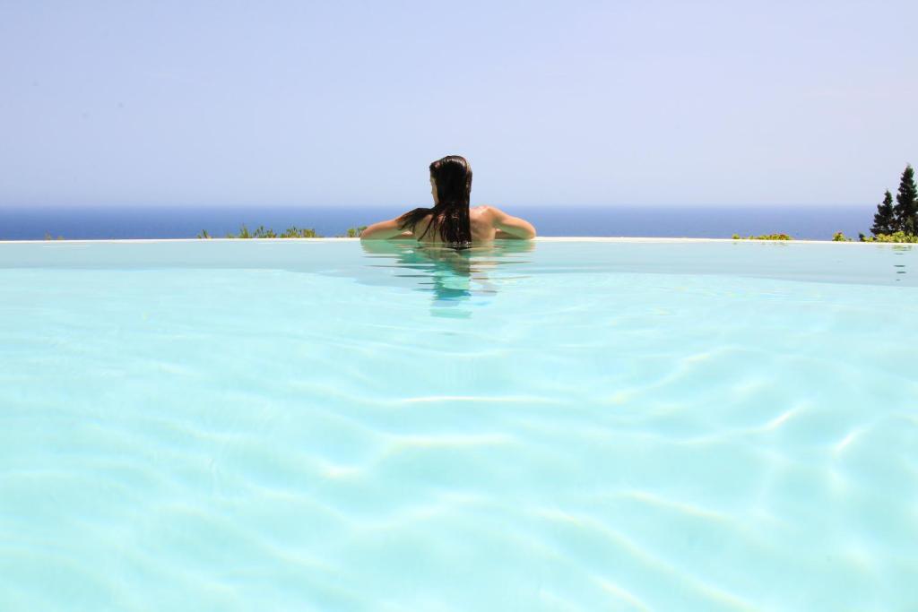 a person in a pool of blue water at Tenuta Belvedere Luxury e Spa in Gagliano del Capo