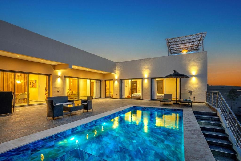 a villa with a swimming pool at night at Villa Ines with heated pool & panoramic views in El Aïn