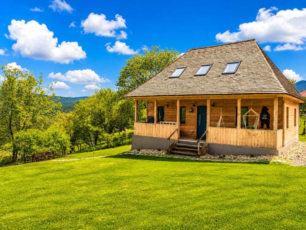 a house on a hill with a green lawn at Casa WEZLY in Măgura