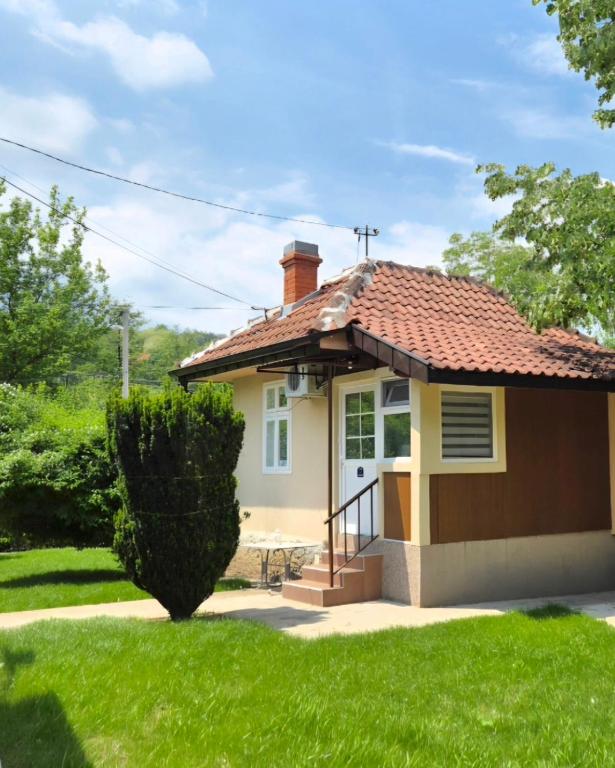 a small yellow house with a red roof at Kucica Yuva in Vrnjačka Banja