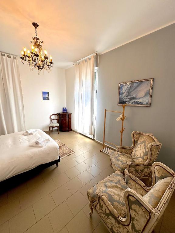 a bedroom with a bed and a chair and a chandelier at Villa Tergeste in Trieste