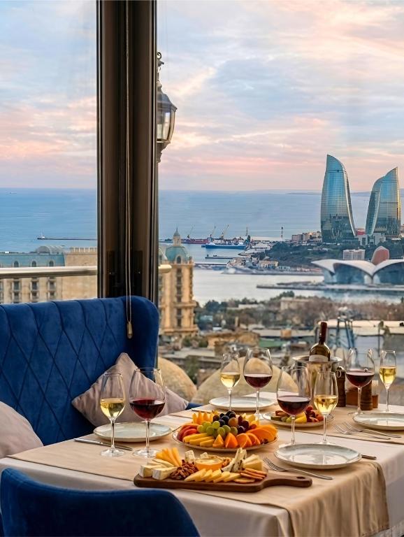 a table with wine glasses and a view of the city at The Moonlight Luxury Hotel in Baku
