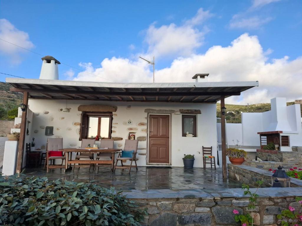 a small white house with a table and chairs at Traditional house paros in Sarakíniko