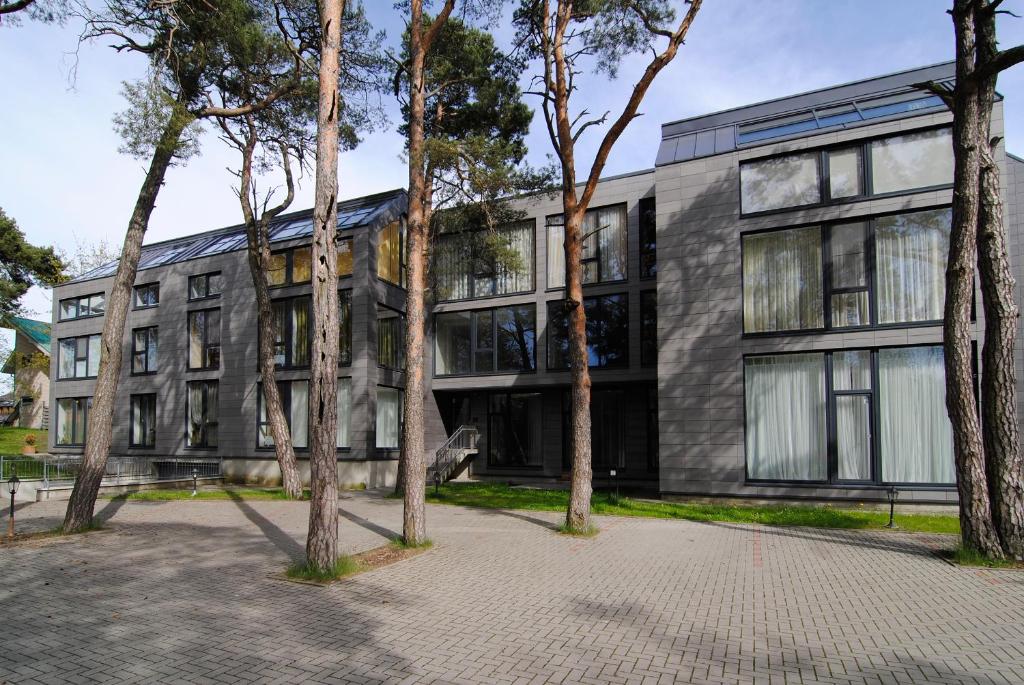 um edifício de escritórios com árvores em frente em Palanga Apartaments - Mickevičiaus 8 em Palanga