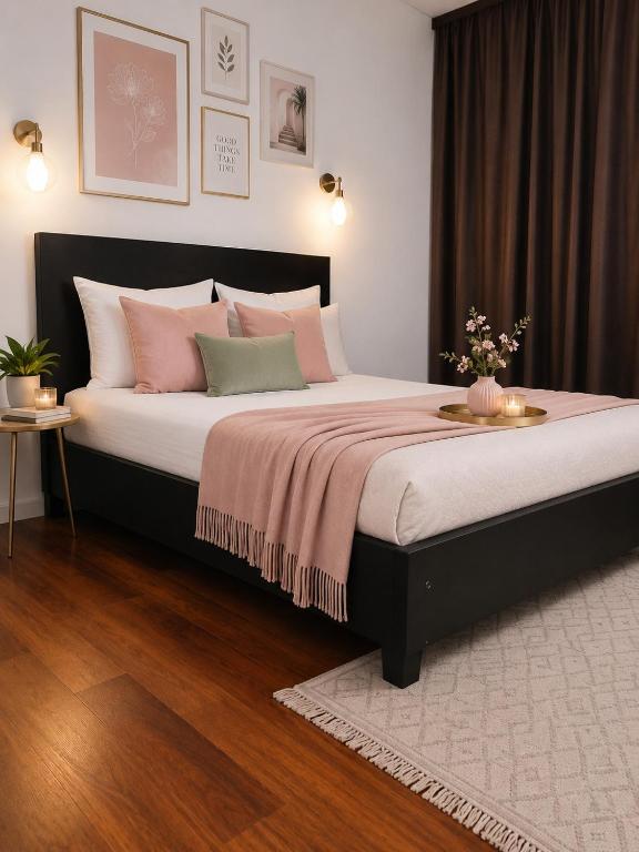 a bedroom with a large bed with pink and green pillows at Vila Roxy Costinesti in Schitul