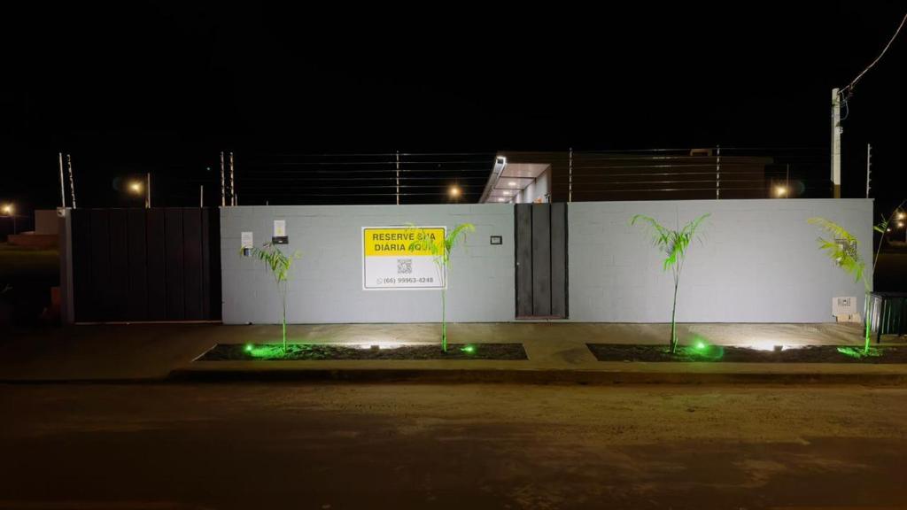 a white building with plants in front of it at night at Hotel Luxx Sorriso in Sorriso