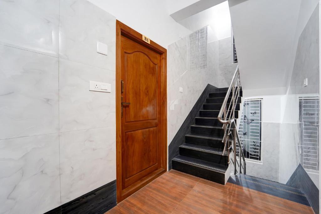 a hallway with a wooden door and stairs at Townhouse Coimbatore International Airport Formerly MK Elegance Inn in Coimbatore