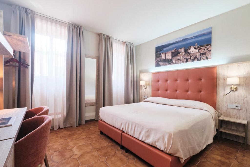 a bedroom with a large bed and a large window at Albergo Della Posta in Bracciano