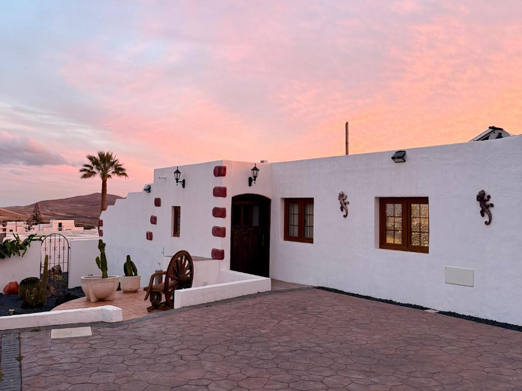 a white building with a sunset in the background at Casa Joanna Lanzarote in Nazaret
