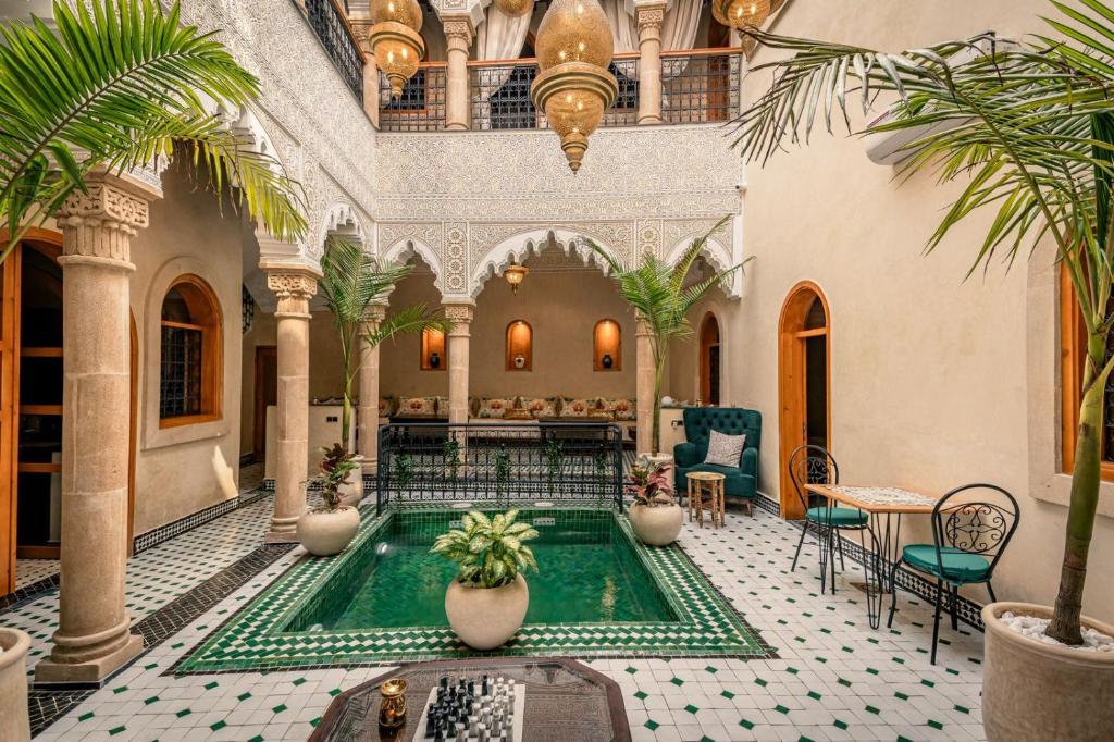 an indoor pool in a building with palm trees at Riad Golden in Rabat