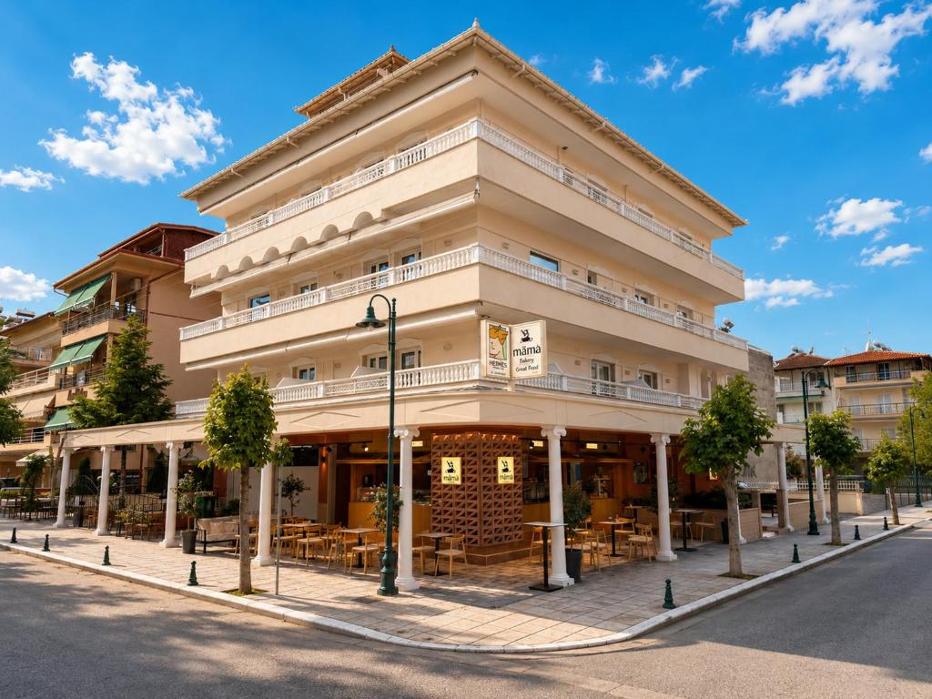 a building on a street with trees in front of it at Hermes Rooms & Suites in Olympic Beach