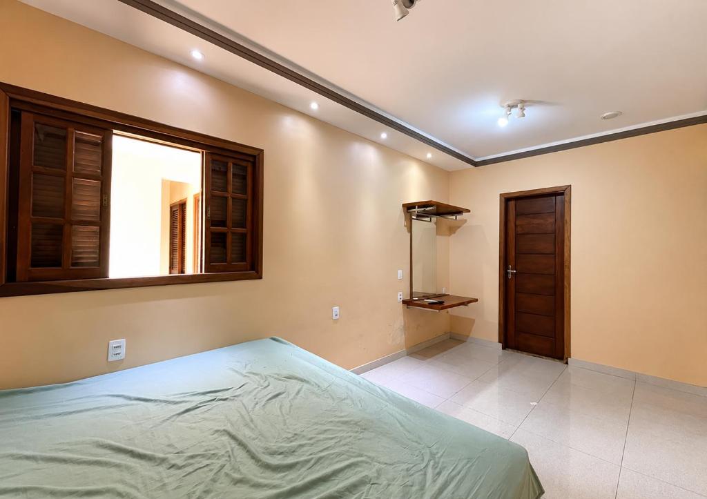 a bedroom with a bed and a window at Pousada Miriam in Limeira