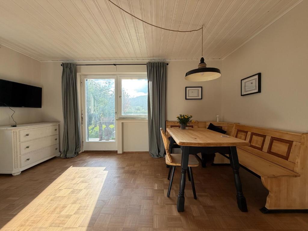 ein Esszimmer mit einem Tisch und einem Fenster in der Unterkunft Murmelruh in Mittenwald