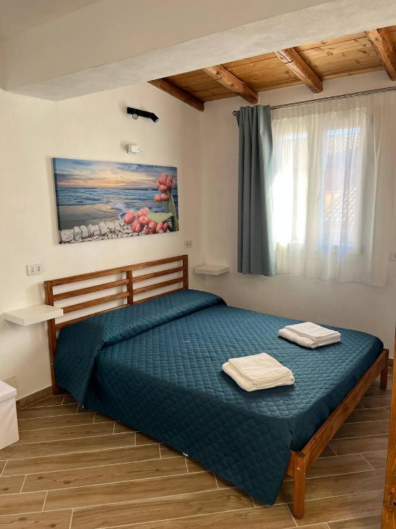 a bedroom with a bed with two towels on it at Apartment, Sulina's House 2 in Campofelice di Roccella