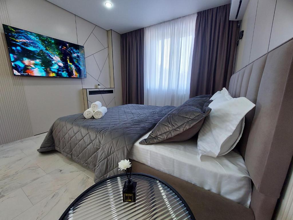a bedroom with a bed with a television on the wall at Премиум квартира в современном стиле in Līsakovsk