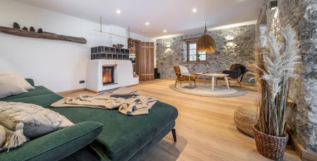 a living room with a green couch and a fireplace at Naturhaus Leger in Lenggries