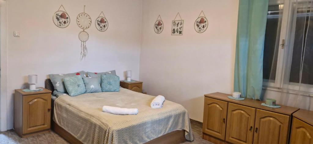 a bedroom with a bed and two dressers with towels on it at Rózsa apartman in Odorheiu Secuiesc