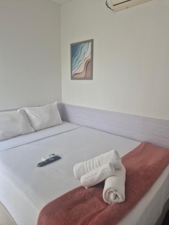 a white bed with a towel on top of it at Repouso Box in Cabo de Santo Agostinho