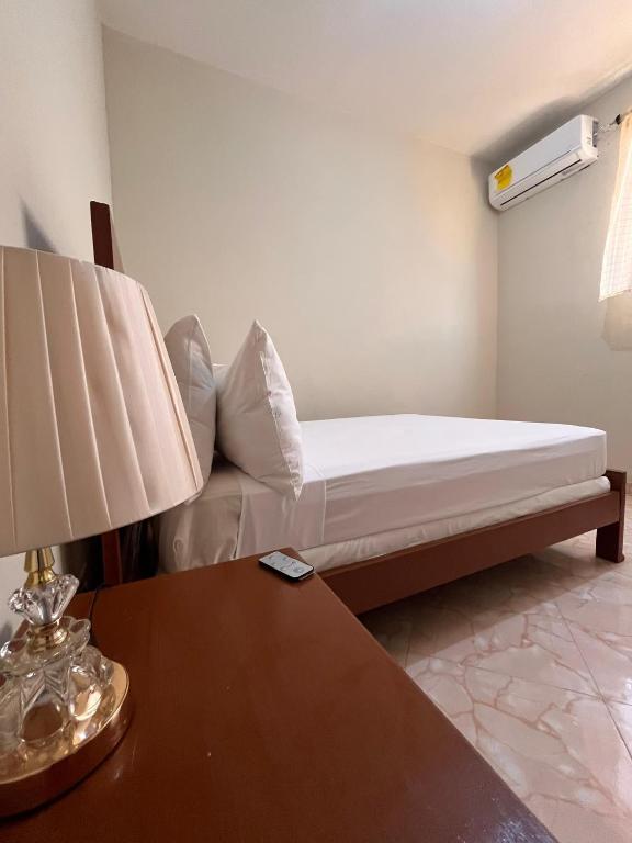 a bedroom with a bed and a table with a lamp at Darlouis hotel cap Haitien in Au Bery