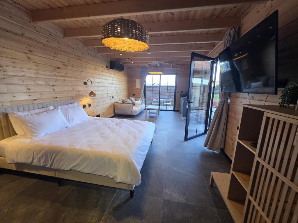 a bedroom with a white bed in a wooden wall at Rosa Carmel in Dāliyat el Karmil