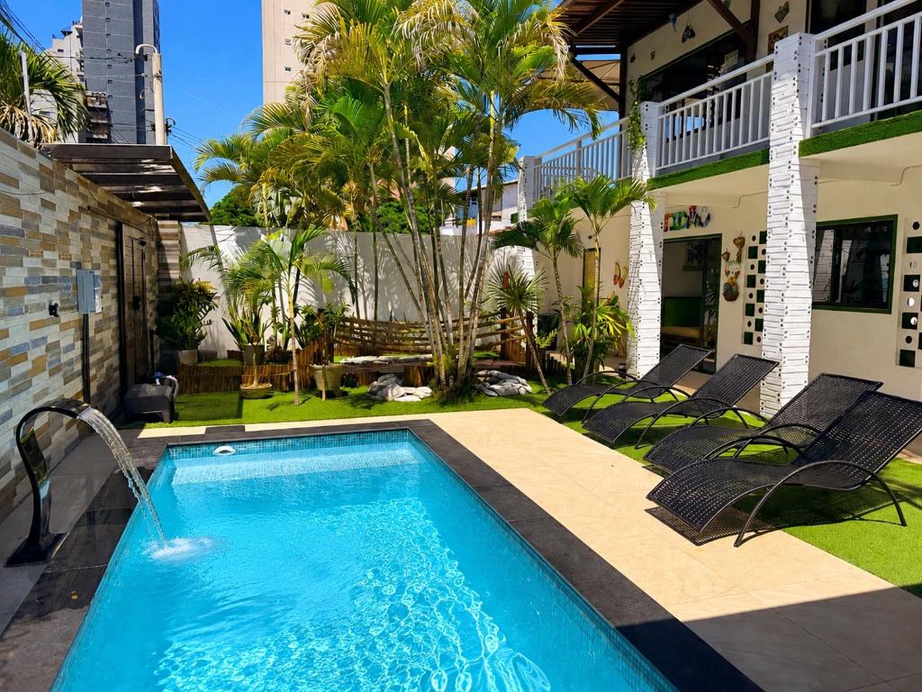 a swimming pool in the backyard of a house at Pousada Jardim Mágico in Ponta Negra