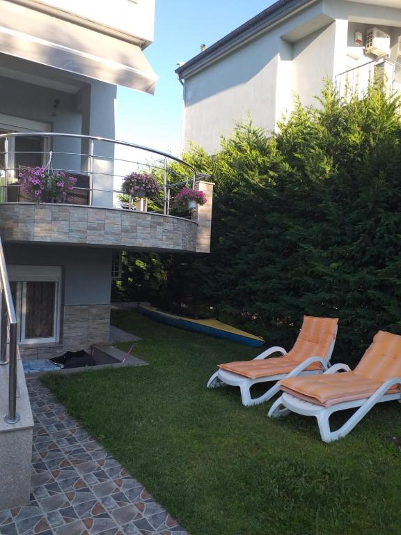two chairs sitting on the grass next to a house at Blue Serenity in Nea Vrasna