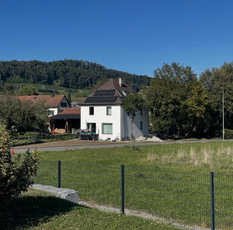 a white house with a fence in a field at Casa Stein am Rhein inkl Pool in Stein am Rhein