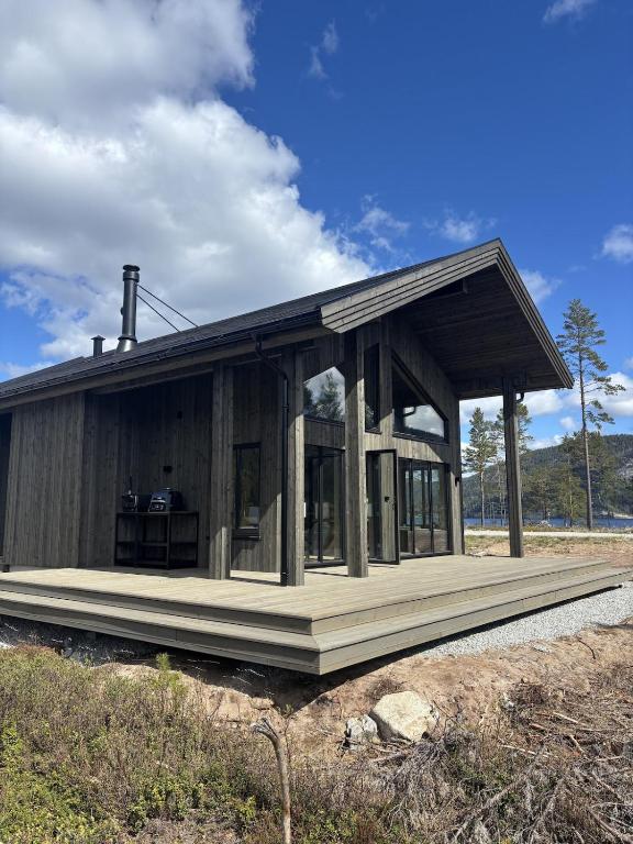 a large wooden house with a large porch at Nisserstrand Hytte mit WLAN und Sauna direkt am See in Treungen