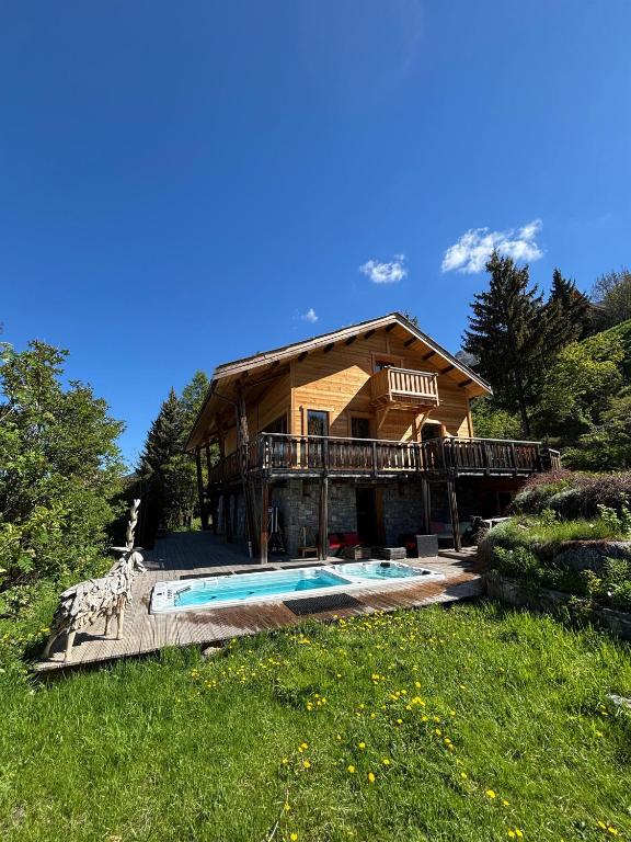 a log house with a swimming pool in front of it at Chalet le Chantelevent for 24 Guests - Slope Views, Pool & Jacuzzi in Vars