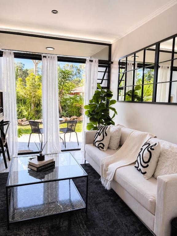 a living room with a white couch and a glass table at Garden View Suite in Gqeberha