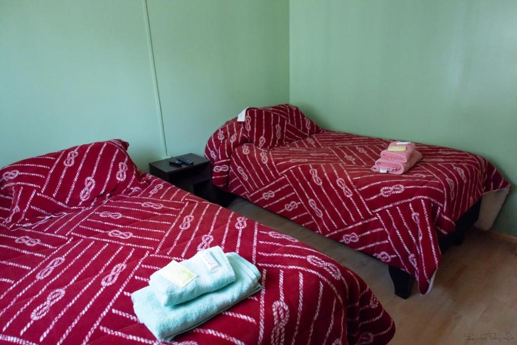 two beds sitting next to each other in a room at Hostal Urenda in Los Ángeles