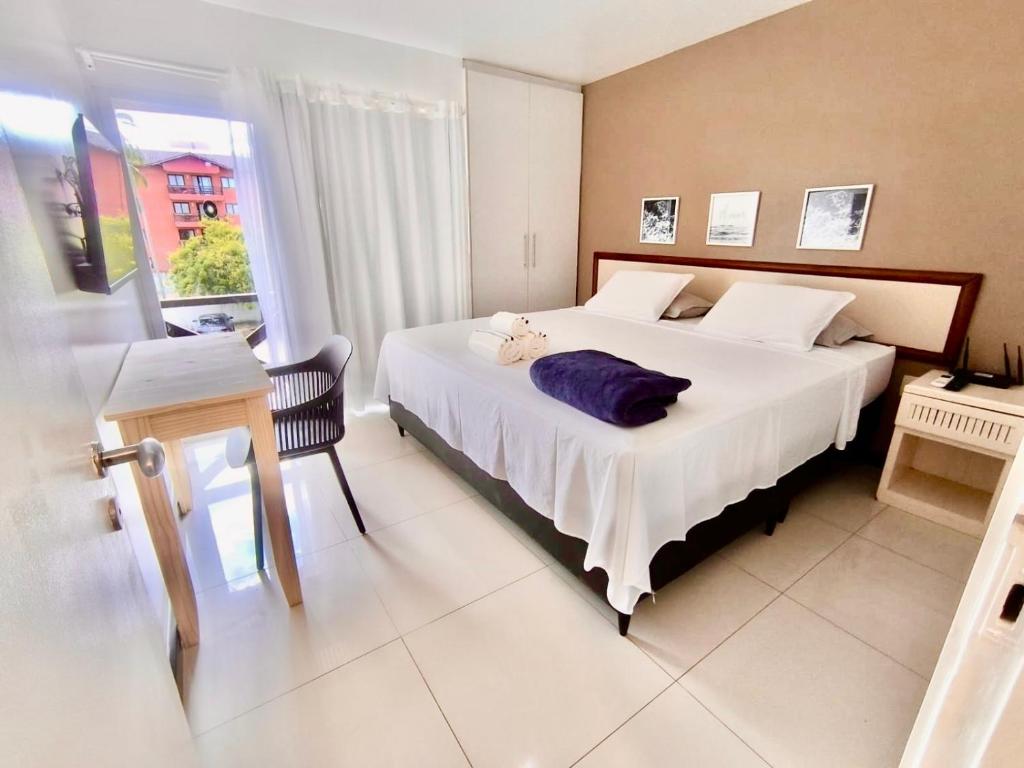 a bedroom with a large white bed and a window at ECO PARADISE -Apt 212 in Caucaia
