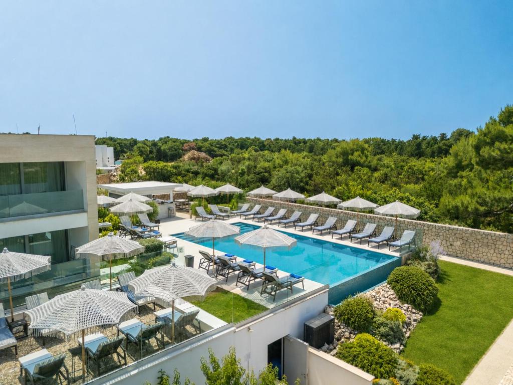 an aerial view of a hotel with a pool and chairs and umbrellas at Hotel Joel in Novalja
