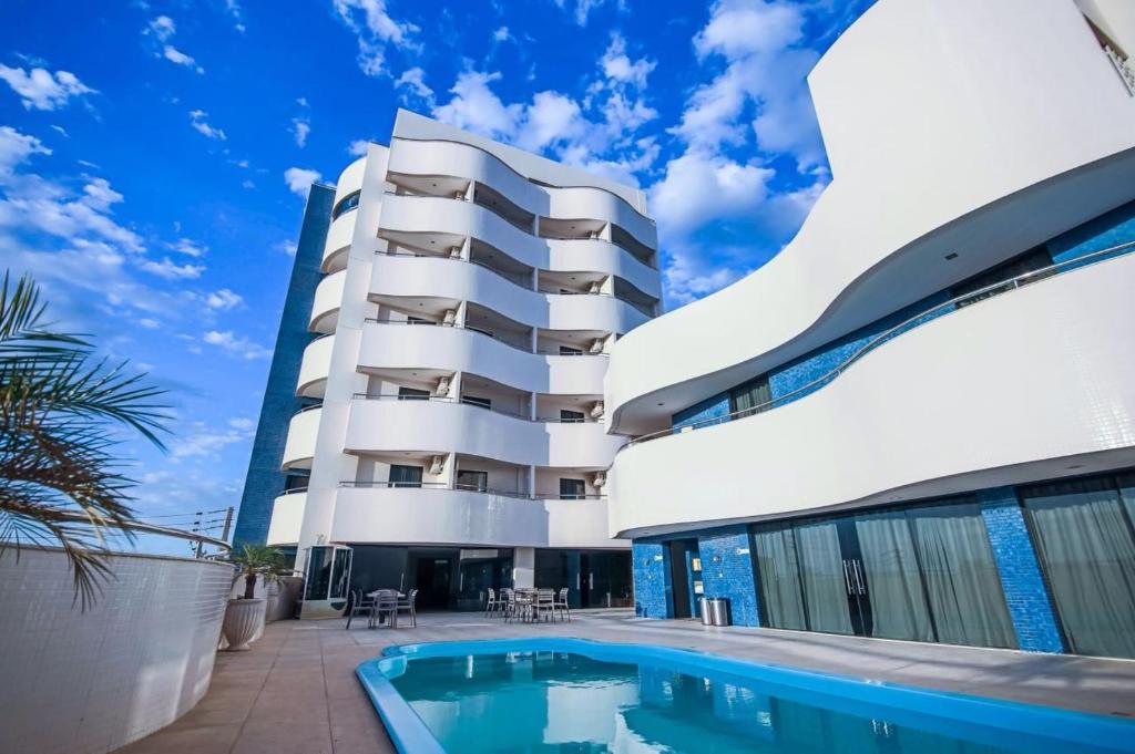 a building with a swimming pool in front of a building at Rapport Hotel in Juazeiro