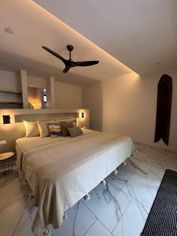 a bedroom with a bed with a ceiling fan at Tamarindo Sunshine in Tamarindo
