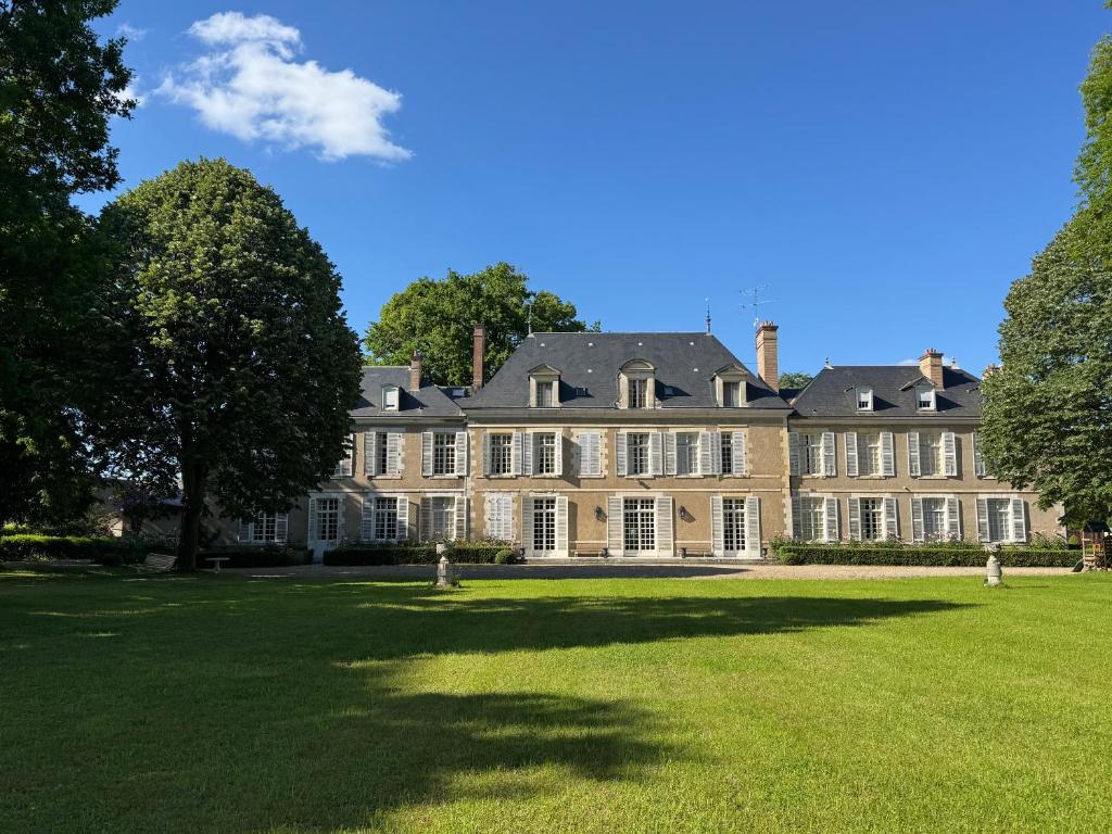 an exterior view of a large mansion with a large lawn at Château de Puchesse in Sandillon