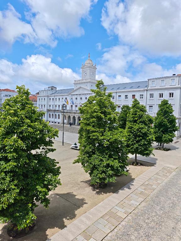 a large white building with trees in front of it at Apartamento Leal Ferrol in Ferrol
